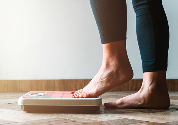 Woman stepping on scale